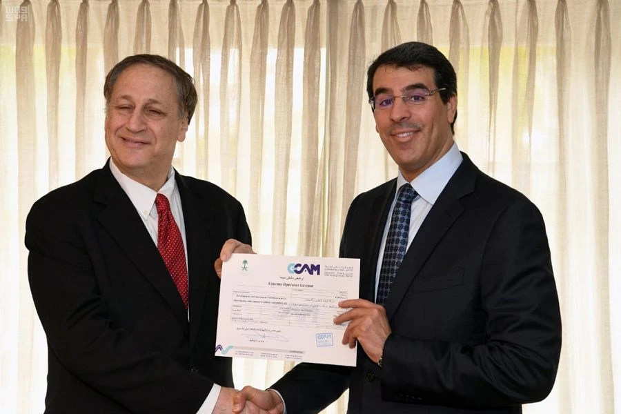 Saudi Minister of Culture and Information Dr. Awad bin Saleh Al-Awad (L) and AMC CEO Adam Aron present the first license for the US-based movie theater company to operate cinemas in Saudi Arabia. (SPA)