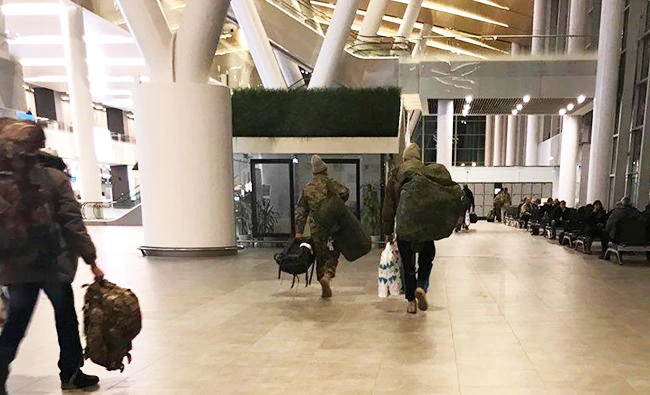 Unidentified men carrying camouflage rucksacks and Damascus airport duty-free bags arrive from Syria at Rostov Airport in Russia, on January 26, 2018. (REUTERS)
