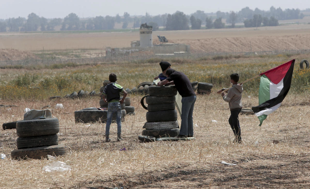 Palestinian protesters set up tires before burning them along Gaza's border with Israel, east of Khan Younis, Gaza Strip, Friday, April 6, 2018. (AP)