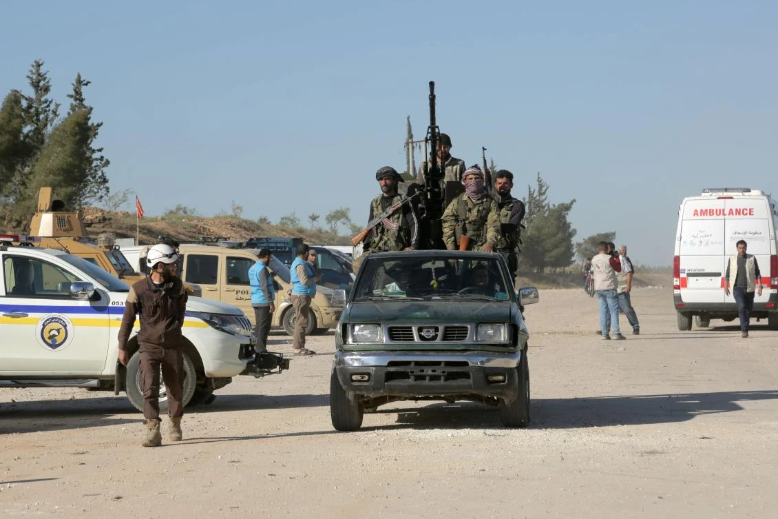 Armed men stand on a pick up as a bus carrying Jaish al-Islam fighters and their families from the former rebel bastion's main town of Douma. (AFP)