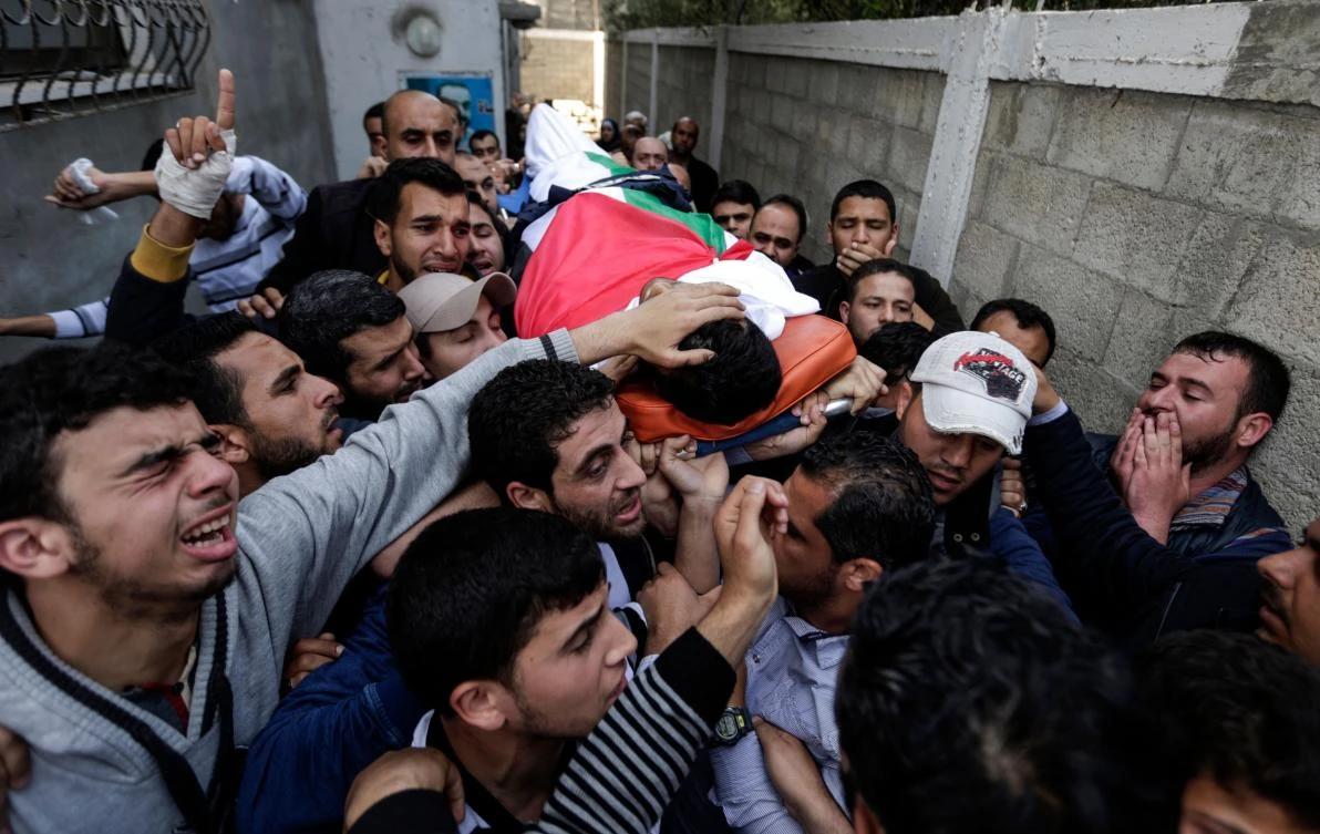Mourners and journalists carry the body of Palestinian journalist Yasser Murtaja, during his funeral in Gaza City on April 7, 2018. (AFP)