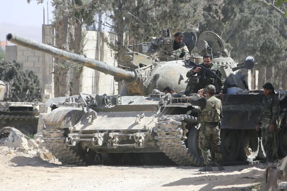 A pro-Syrian regime fighter takes a picture of a comrade on top of a tank as they prepare to advance toward the town of Douma, the last opposition holdout in Eastern Ghouta, on April 7, 2018. (AP)