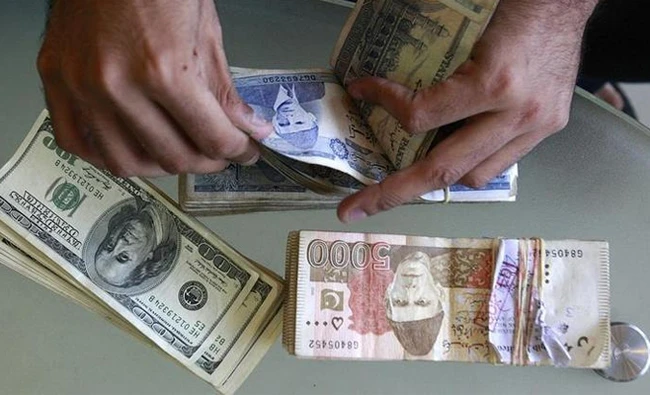 In this file photo, A currency dealer counts Pakistani rupees and US dollars at his shop in Karachi, Pakistan. (REUTERS)