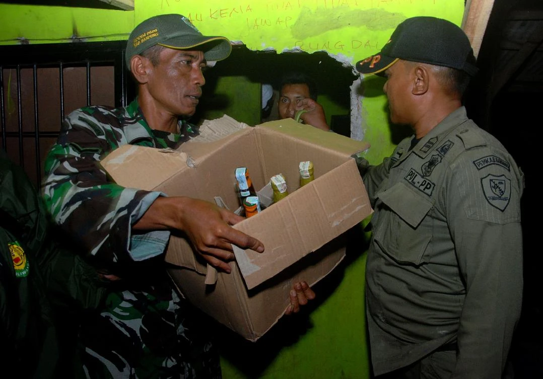 Indonesian police remove bottles of illegal alcohol from a house in Cicalengka district in West Java province on April 8, 2018. (AFP)