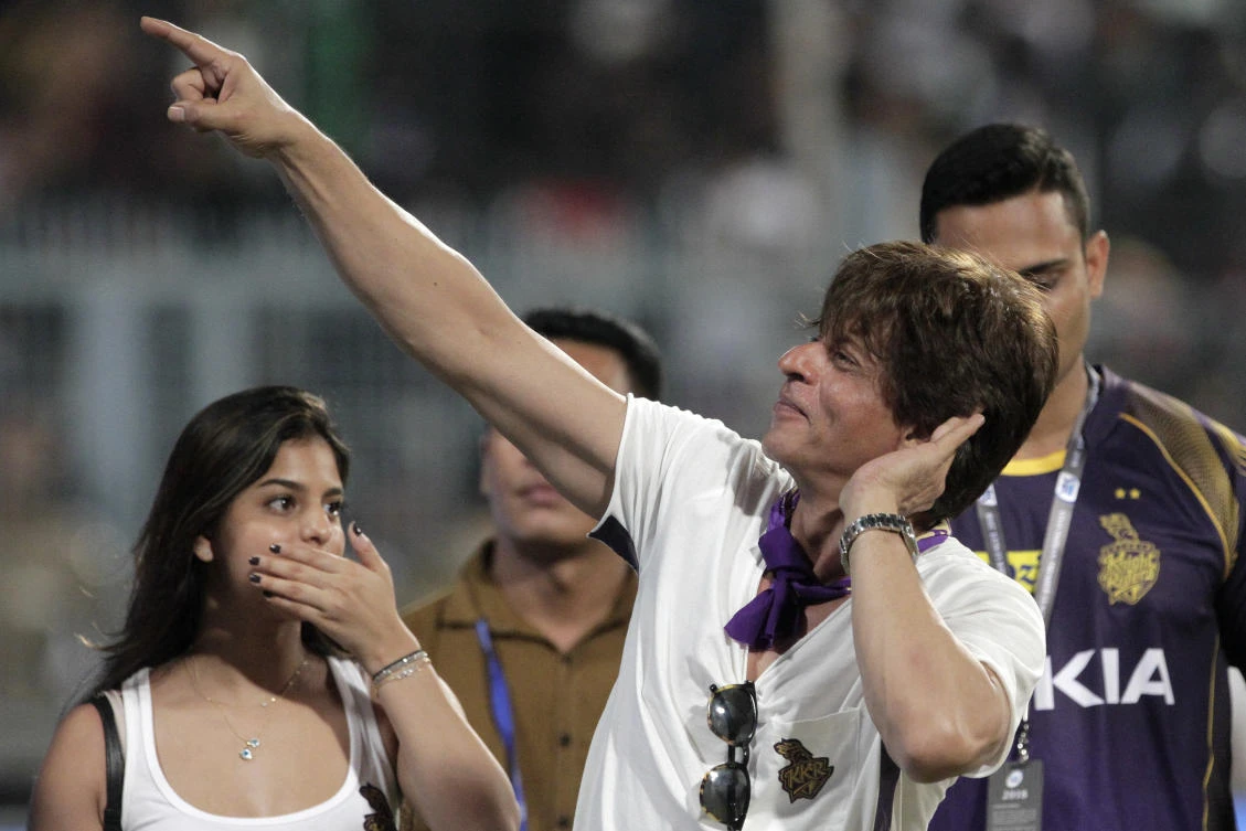 Bollywood actor and co-owner of Kolkata Knight Riders Shah Rukh Khan gestures towards the crowd as he walks around the venue with his daughter Suhana Khan after his team beat Royal Challengers Bangalore in their opening IPL game of 2018. (AP)