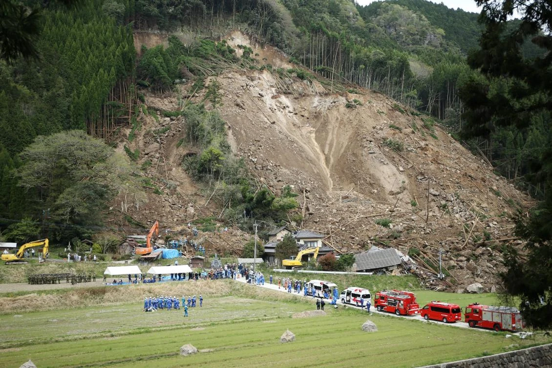Rescue and police personnel work as the scene of a landslide that hit residential homes in Nakatsu, Oita prefecture on Wednesday, April 11. (Jiji Press / AFP)