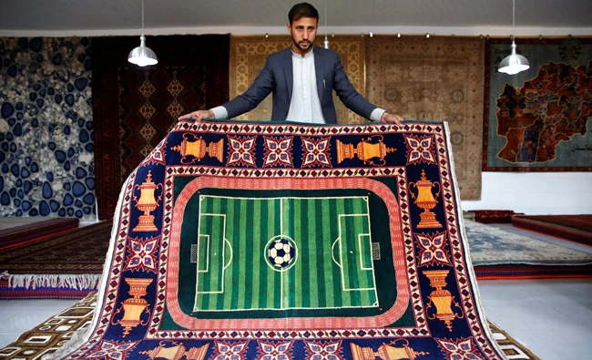 A vendor shows a carpet at the Afghanistan Rug and Carpet Center show room in Kabul, Afghanistan on April 1, 2018. (REUTERS)