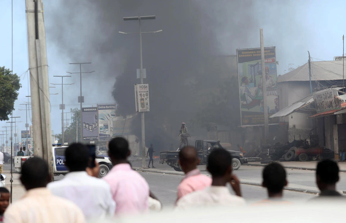 Civilians look on as smoke billows from the scene of an explosion at a security checkpoint in the Hodan district of Mogadishu. Somalia has been wracked by violence during the past days. (Reuters)