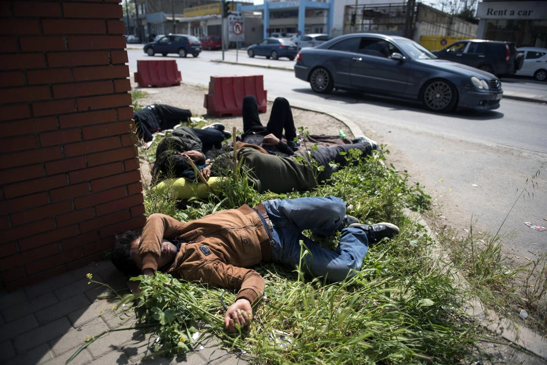 Migrants sleep outside police HQ in the northern Greek city of Thessaloniki. Several hundred refugees and migrants have gathered outside a police station in Greece’s second largest city, waiting for hours to be formally arrested and gain temporary residence in the EU country. (AP Photo)