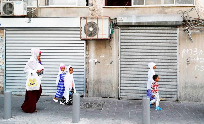 Illegal migrants from Eritrea walk in the street in a southern district of the Israeli city of Tel Aviv on April 5, 2018. (AFP)
