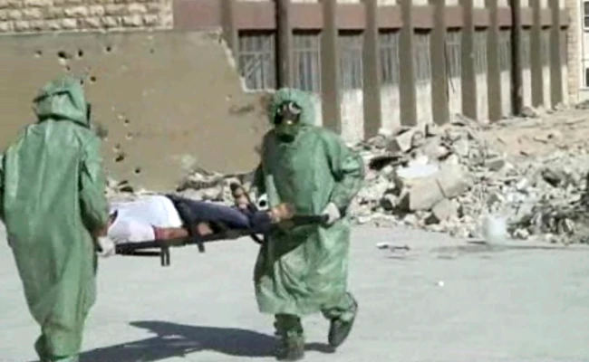 This file image made from an AP video posted on Sept. 18, 2013 shows Syrians in protective suits and gas masks conduct a drill on how to treat casualties of a chemical weapons attack in Aleppo, Syria. A huge explosion was heard in southern Aleppo on Saturday. (AP)