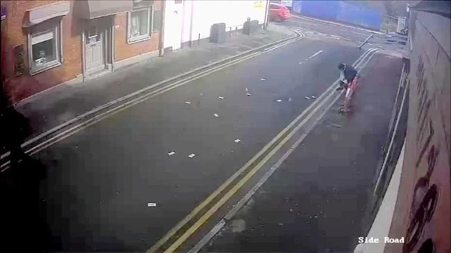 GMP CCTV footage showing UK robber's money blowing away in the wind. (Screengrab)