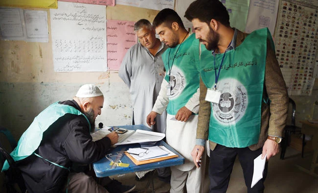 Afghan employees of the Independent Election Commission (IEC) registering a resident at a voter registration center for the upcoming parliamentary and district council elections in Kabul on April 14, 2018. (AFP)