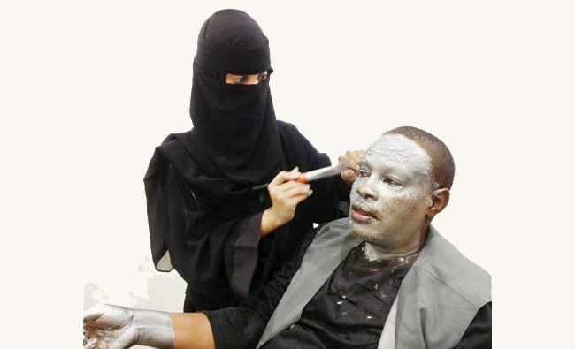 Saudi artist Ohoud Mohammed applies make-up for Al-Ameri before he could get on the stage in Jeddah. AN