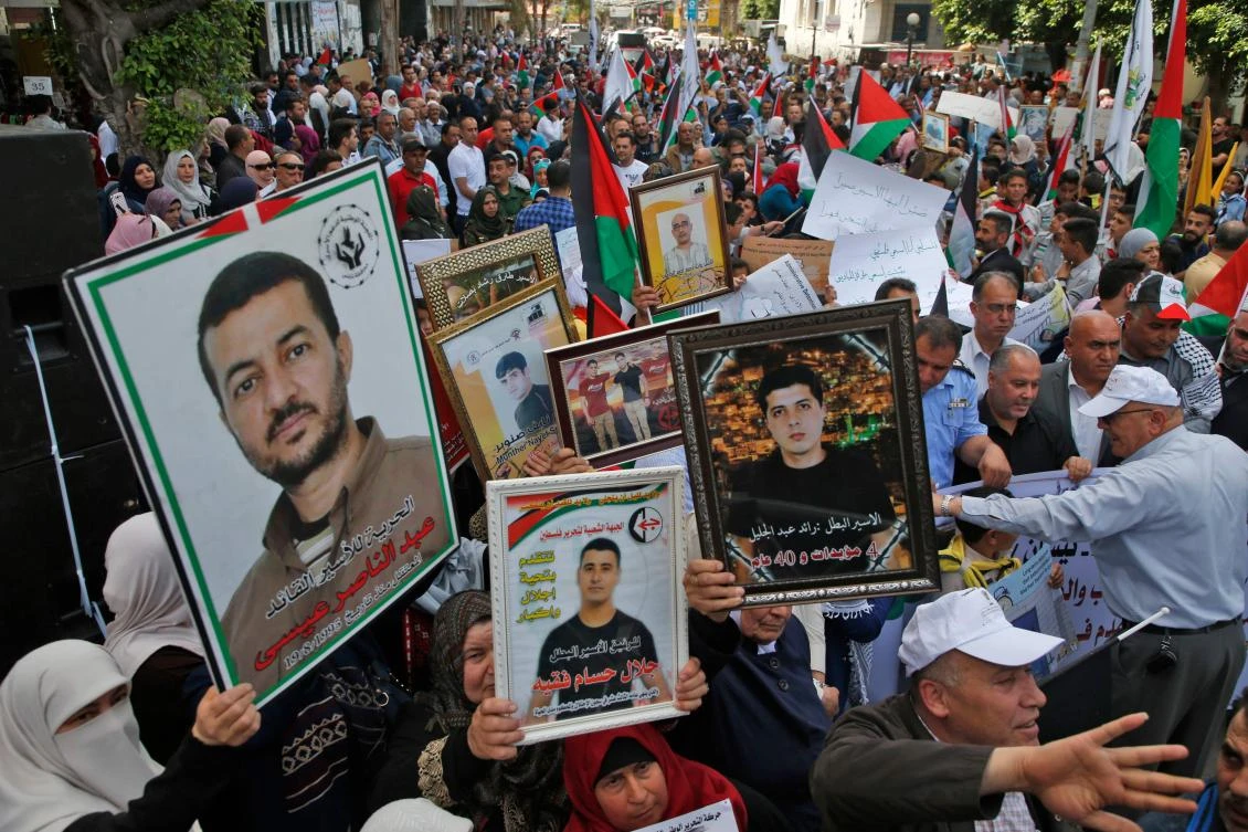 Palestinians hold portraits of relatives jailed in Israeli prisons as they protest to demand for their release during a demonstration to mark the Prisoners’ Day in the northern West Bank city of Nablus. (AFP)