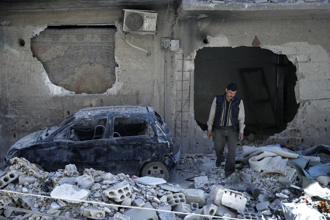 In this Monday, April 16, 2018 photo, man walks just meters away from where the alleged chemical weapons attack occurred in the town of Douma, the site of a suspected chemical weapons attack, near Damascus, Syria. (AP)