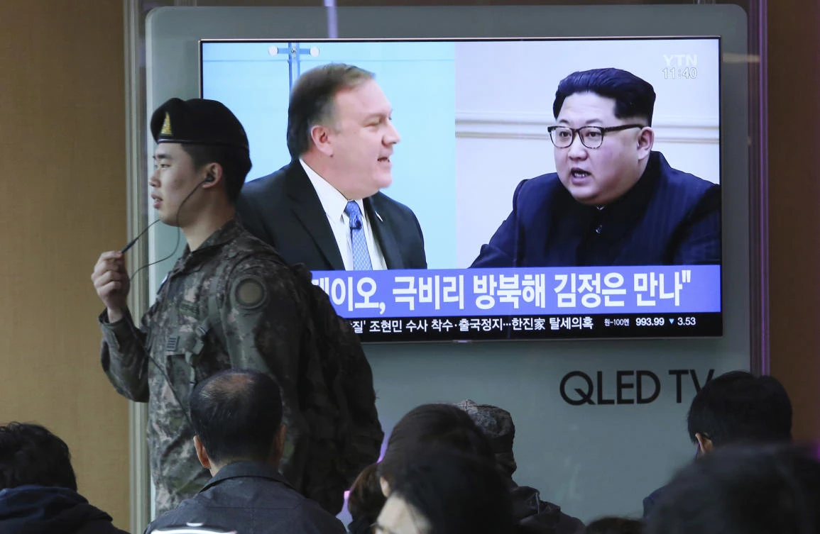 A South Korean army soldier passes by a TV screen showing file footage of CIA Director Mike Pompeo, left, and North Korean leader Kim Jong Un during a news program at the Seoul Railway Station in Seoul on Wednesday, April 18. (AP)