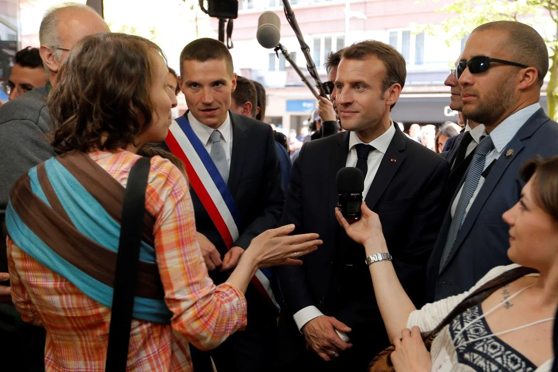 French President Emmanuel Macron listens to a woman in a market on April 18, 2018 as part of his three days tour of eastern France. (AFP)
