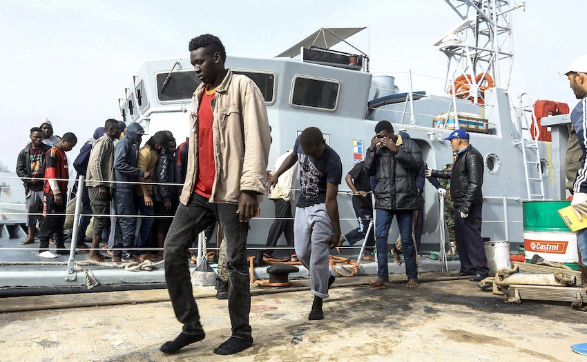 African migrants rescued from a ship off the coast of Zawiyah, about 45 kilometers west of the Libyan capital Tripoli, disembark at the dock at the capital’s naval base. (File Photo: AFP)