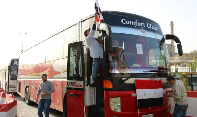 A bus carrying Syrian refugees evacuated from the southern Lebanese village of Shebaa passes through the Masnaa crossing on the Lebanon-Syria border leading to Damascus on April 18, 2018. The refugees were returning to their village of Beit Jinn in the southwestern Damascus countryside. (AFP / HASSAN JARRAH)