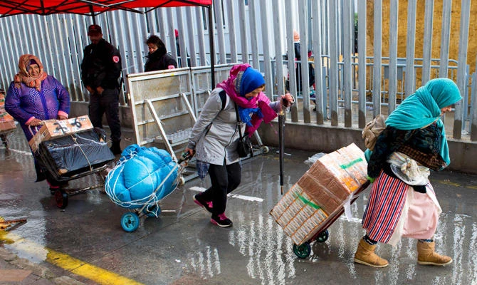 Female Moroccan porters use trolleys to transport bundles of goods across the El-Tarajal border from Spain's North African enclave of Ceuta into Morocco on April 12, 2018. (AFP / FADEL SENNA)