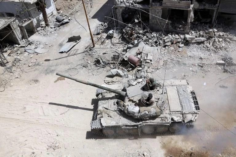 A picture taken on April 8, 2018, shows Syrian Army soldiers advancing in an area on the eastern outskirts of Douma, as they continue their fierce offensive to retake the last opposition holdout in Eastern Ghouta. (AFP)