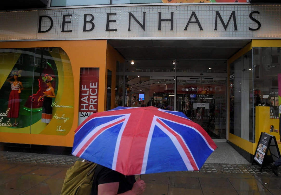 A shopper walks past a Debenham's store in central London. The retailer has added to the gloom in the retail sector with a profits warning.
