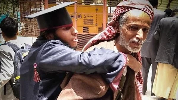 A picture of an elderly father carrying his disabled son during his graduation ceremony in Yemen went viral on Arabic social media accounts.