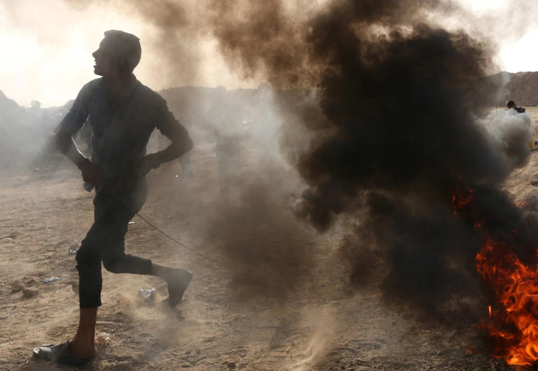 A Palestinian hurls stones at Israeli troops during clashes at Israel-Gaza border in the central Gaza strip early this week. (Reuters)