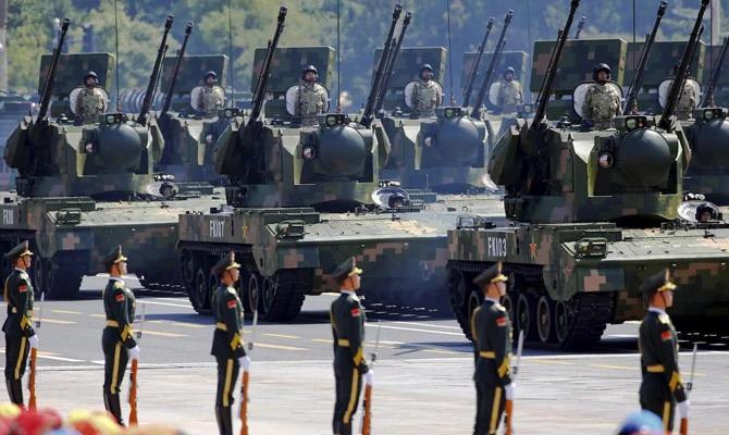 China’s soldiers on their armored vehicles equipped with anti-aircraft artillery roll on to Tiananmen Square during a military parade in Beijing. Reuters