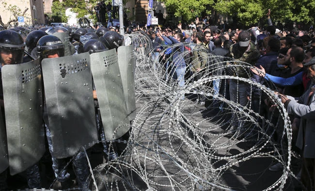 Police stop opposition demonstrators as they march to protest the former president's shift into the prime minister's seat in Yerevan, Armenia, on April 16, 2018. (AP)