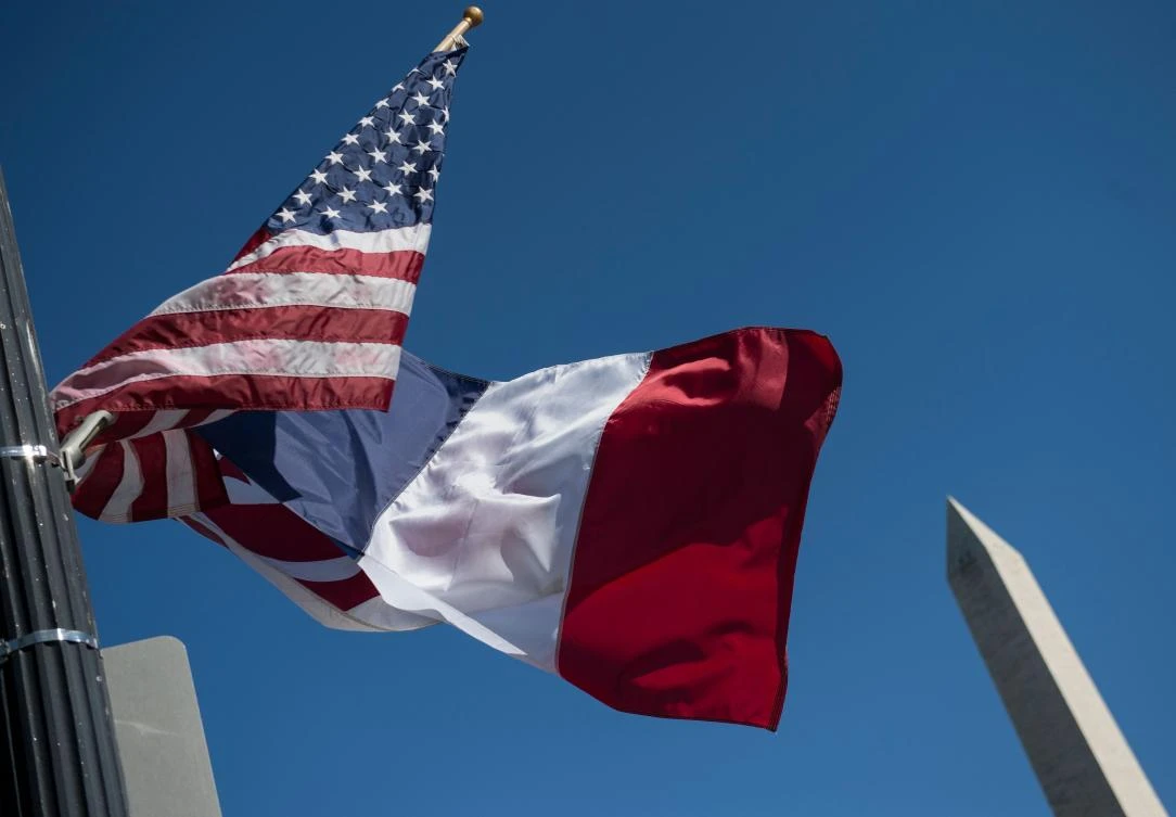 A US national flag, French flag(C) and Washington,DC flag fly near the Washington Monument in Washington, DC on April 20, 2018, the week before the visit of French President Emmanuel Macron. (AFP/Andrew Caballero-Reynolds)