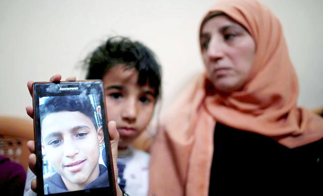 The mother of Mohammed Ayoub shows her son’s photo at her house in the northern Gaza Strip on April 21, 2018. (Reuters)