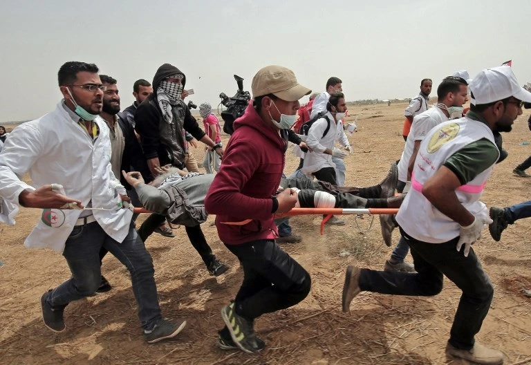 Palestinian medics evacuate a wounded protester during clashes with Israeli forces on April 20, 2018. (AFP)