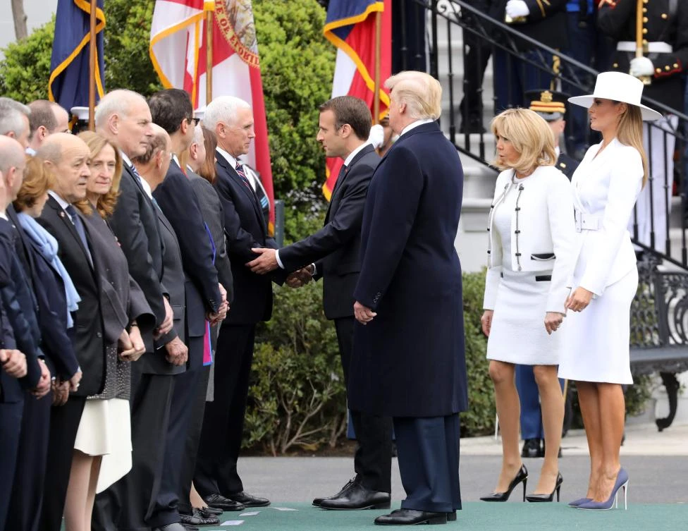 French President Emmanuel Macron shakes hands with US Vice President Mike Pence as US President Donald Trump (C), First Lady Melania Trump (R) and Brigitte Macron watch, during a state welcome at the White House in Washington, D.C. (AFP)