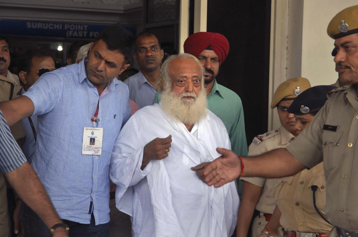 Spiritual guru Asaram Bapu, center, is brought for interrogation by police at Jodhpur airport in Jodhpur in 2013. The verdict against 77-year-old Bapu was read out inside a prison in the city of Jodhpur in Rajasthan state because of fears that his followers may resort to violence. (AP)