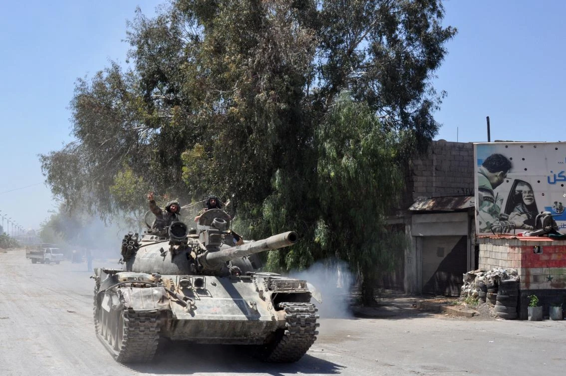 A Syrian government tank drives down a street in Al Hajar al Aswad, on April 23, 2018, during a regime offensive targeting the Islamic State group in the southern districts of Damascus. (AFP)