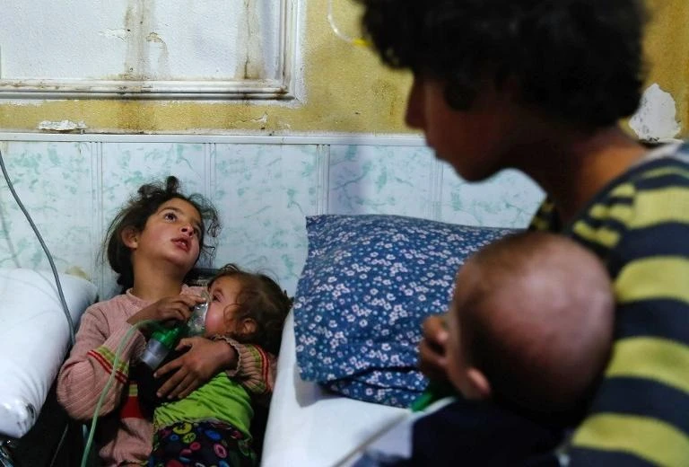 File Photo showing a Syrian girl holds an oxygen mask over the face of an infant at a make-shift hospital following a reported gas attack on the rebel-held besieged town of Douma in the eastern Ghouta, near Damascus, Jan 2018. (Reuters)