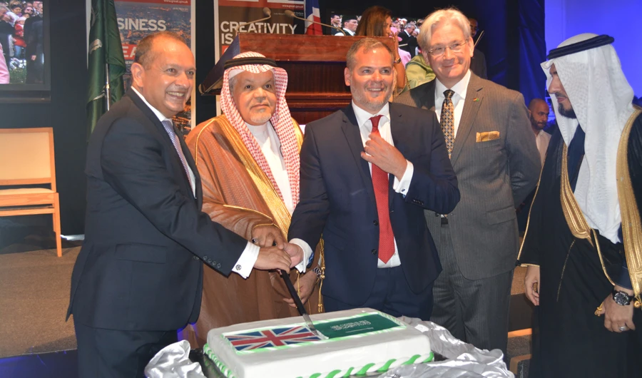 Foreign Ministry official Jamal Balkhaior joins British Ambassador Simon Collis and Consul General Barrie Peach to cut the cake in Jeddah on Monday. (AN photo)