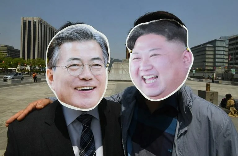 South Korean activists wearing masks of South Korean President Moon Jae-in, left and North Korean leader Kim Jong Un pose for a photo during a rally to support the upcoming inter-Korean summit. (AFP)