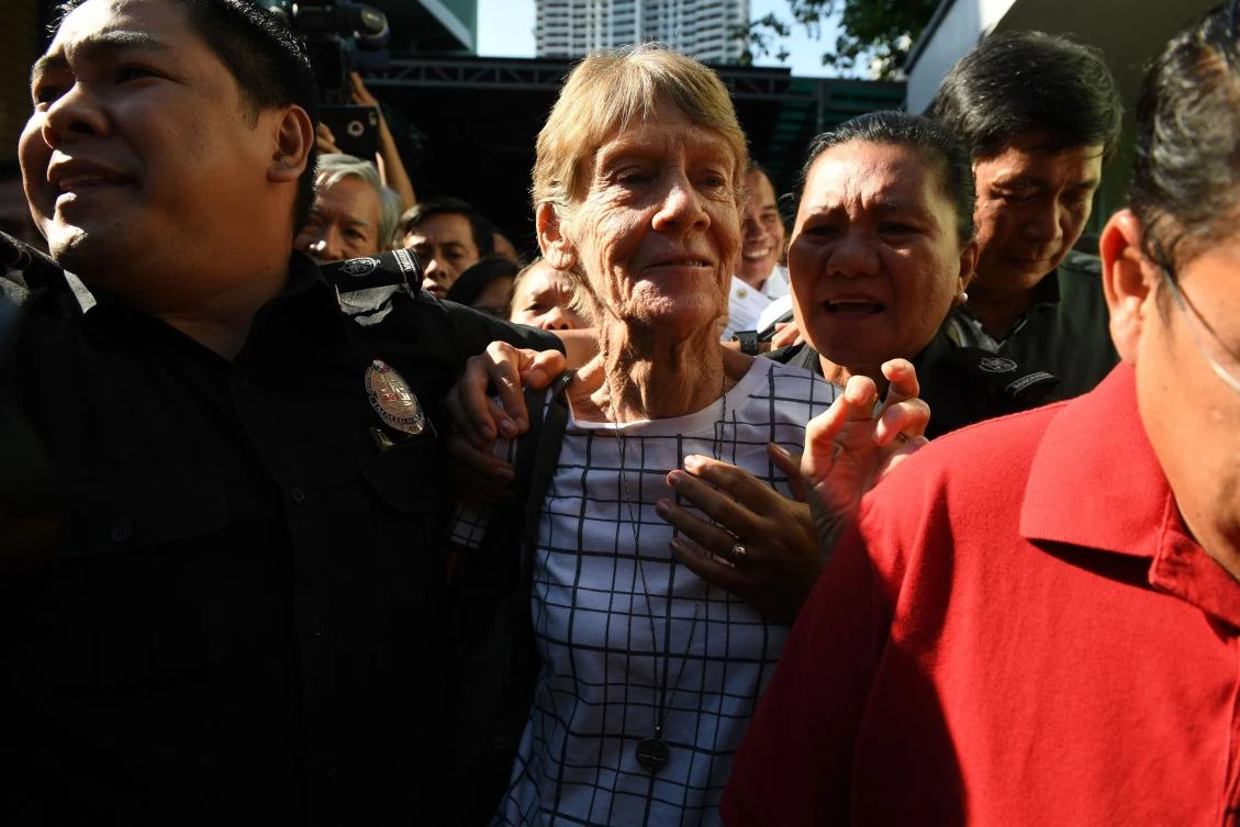 Australian catholic nun Sister Patricia Fox (C) is escorted by immigration officers during her release from detention at the Immigration headquarters in Manila on April 17, 2017, a day after she was arrested. (AFP/Ted Aljibe)