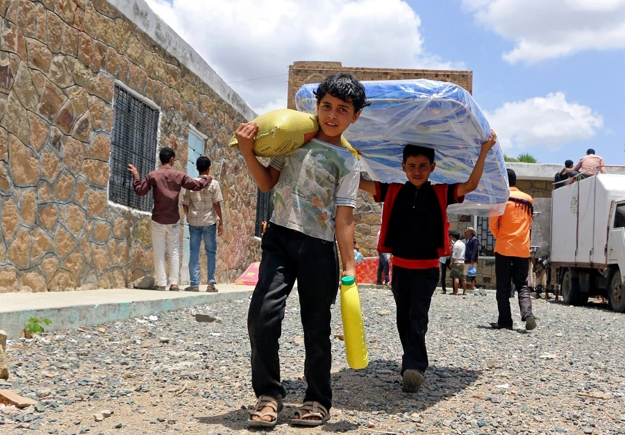 Boys carry relief supplies to their families who fled fighting in the southern city of Aden, in Taiz, Yemen. Saudi Arabia said Sunday, Jan. 21, 2018. (AP /Abdulnasser Alseddik, File)