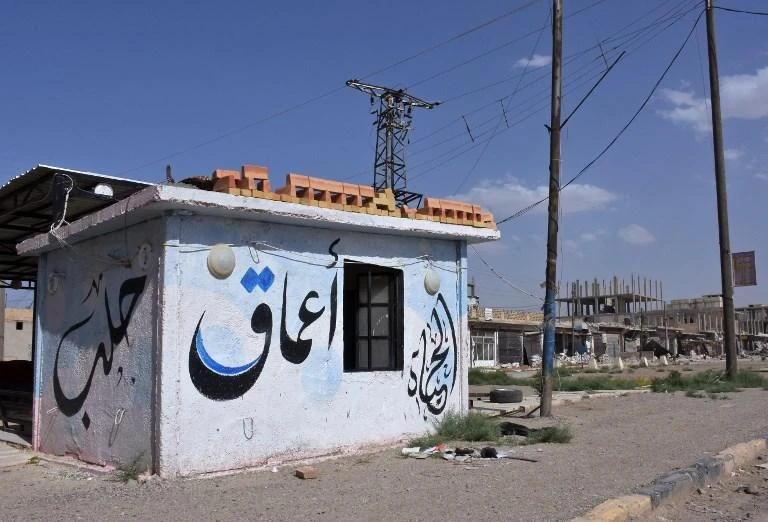Above, a building with the Arabic word ‘Amaq’, which is the name of the propaganda arm of the militant Daesh group, in the northern Syrian town of Maskanah. (AFP)