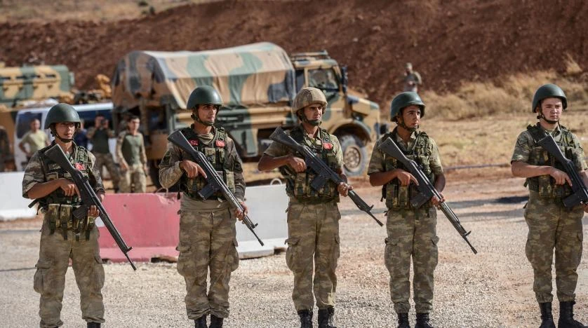 Turkish soldiers stand near armored vehicles near the Turkey-Syria border in this file photo. (AFP)