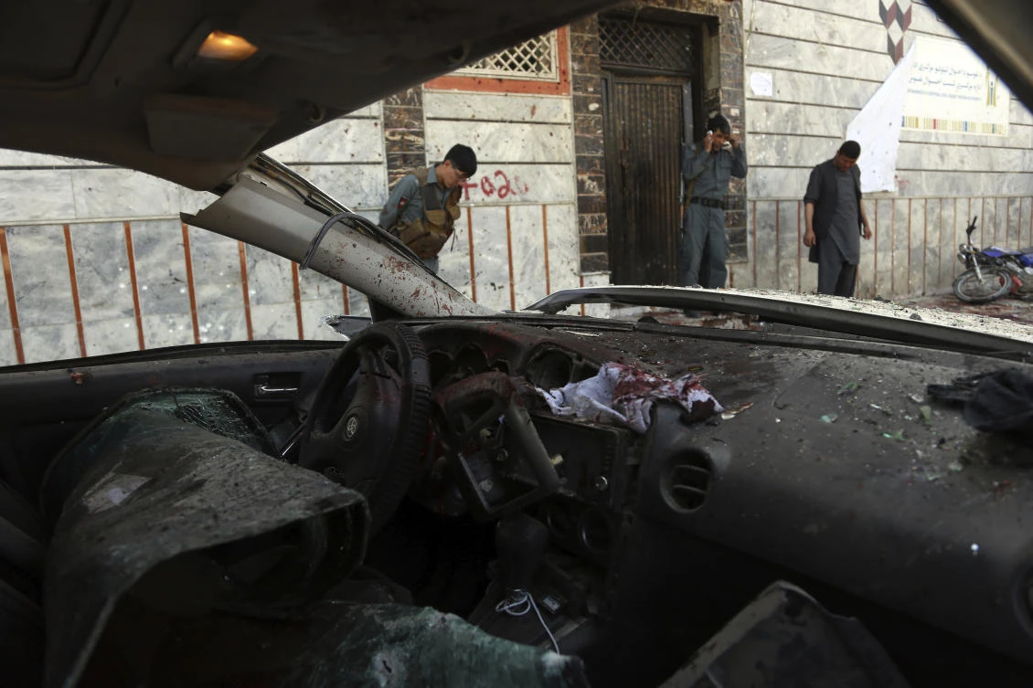 Afghan security personnel stand outside a voter registration center, after a suicide attack in Kabul, Afghanistan, Sunday, April 22, 2018. (AP)