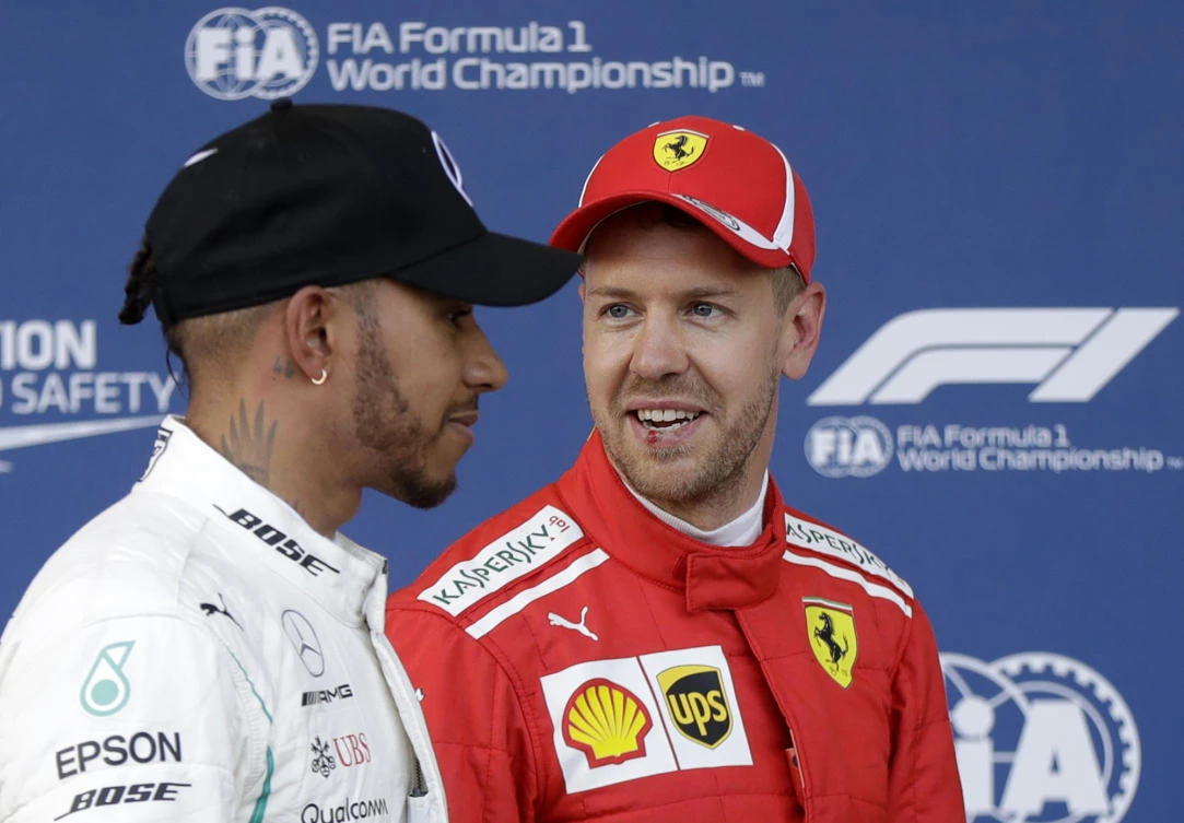 Mercedes driver Lewis Hamilton of Britain, left, and Ferrari driver Sebastian Vettel of Germany chat at the end of the qualifying session at the Baku Formula One city circuit, in Baku, Azerbaijan, Saturday, April 28, 2018. The Formula One race will be held on Sunday. Vettel clocked the fastest time and Hamilton was second. (AP Photo/Luca Bruno)