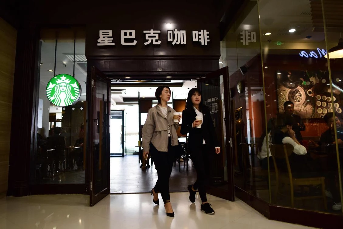 Two women walk out of a Starbucks coffee shop in Beijing. US President Donald Trump's tariffs on Chinese goods have roused some nationalist sentiment in the world's second largest economy, where consumers have a long track record of spurning foreign products when political nerves are frayed. (AFP)