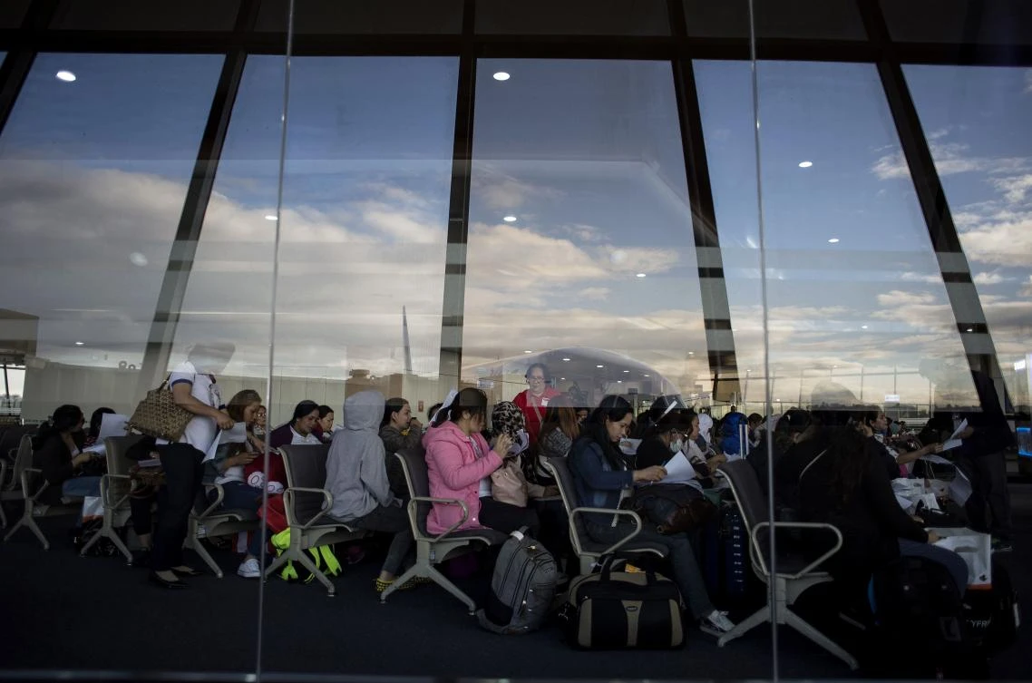 Filipina workers returning home from Kuwait fill out forms upon their arrival at Manila International Airport. (AFP)