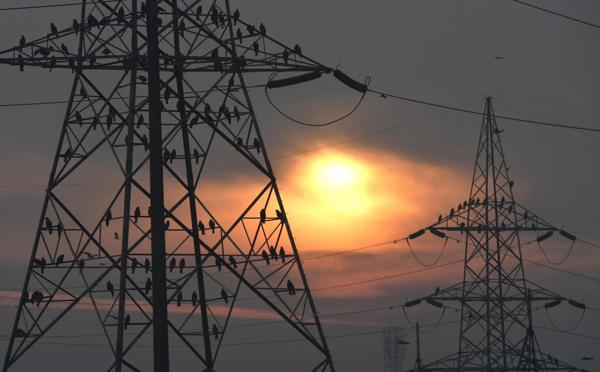 In this file photo taken on February 17, 2017 birds sit on electricity pylons as the sun rises behind them on the outskirts of New Delhi. More than 16,000 Indian villages have been electrified since Prime Minister Narendra Modi was elected in 2014, according to government data. (Prakash Singh/AFP)