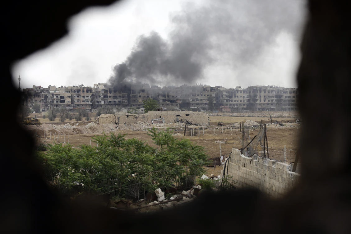 A file photo of smoke rising from buildings in Yarmuk, a Palestinian refugee camp on the edge of the capital. (Louai Beshara/AFP)